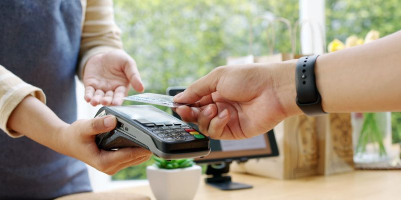 client payant en sans contact avec sa carte bancaire sur un tpe ingenico