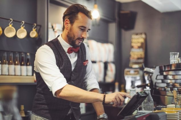 barman utilisant une caisse enregistreuse