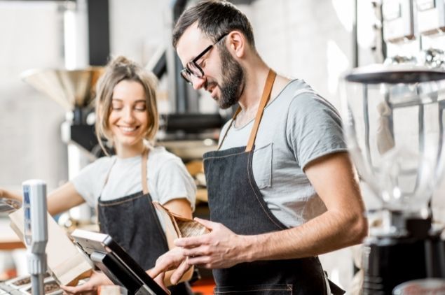 caissier utilisant une caisse enregistreuse pour régler un produit