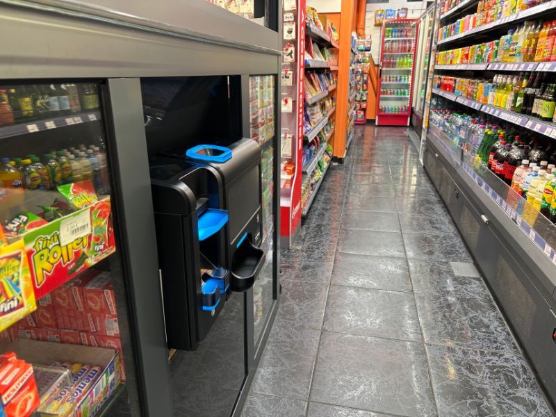 Monnayeur automatique installé au comptoir d'un Franprix