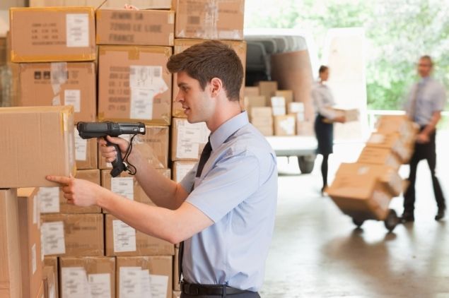 homme utilisant terminal d'inventaire dans un entrepôt